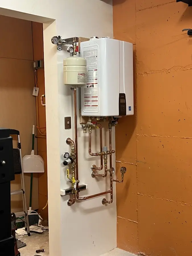 Plumbing technician inspecting water heater connections in Lincoln